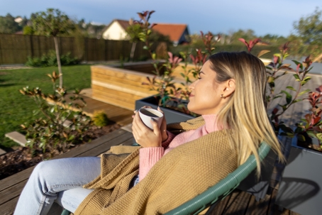 Woman sitting on patio drinking tea.